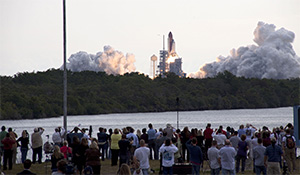 Croud observing Space Shuttle launch from a distance at NASA Kennedy Space Center