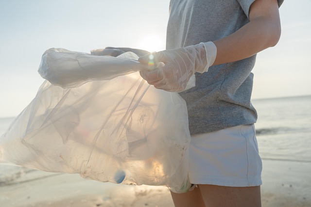 Teen holding trash bag on beach